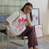 Woman sitting on a chair in a room with glass block wall and framed pictures.